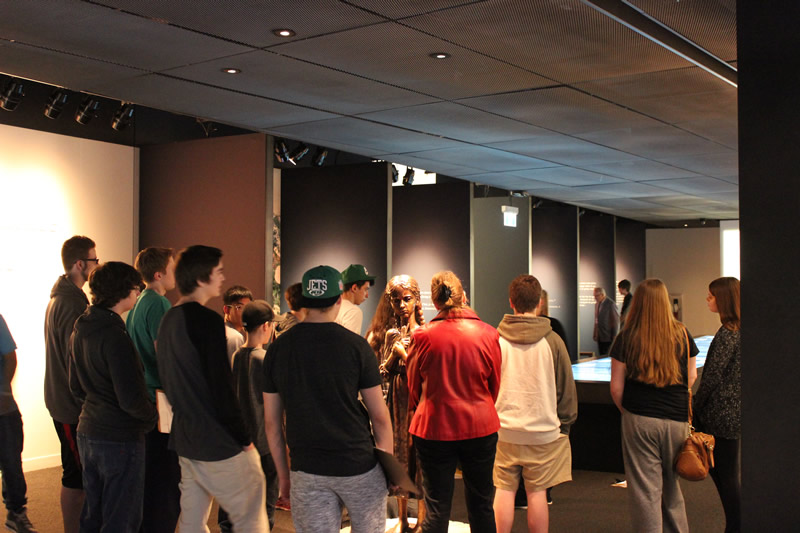 Students gathering around a guide in the Breaking the Silence Gallery (Tourism Winnipeg)