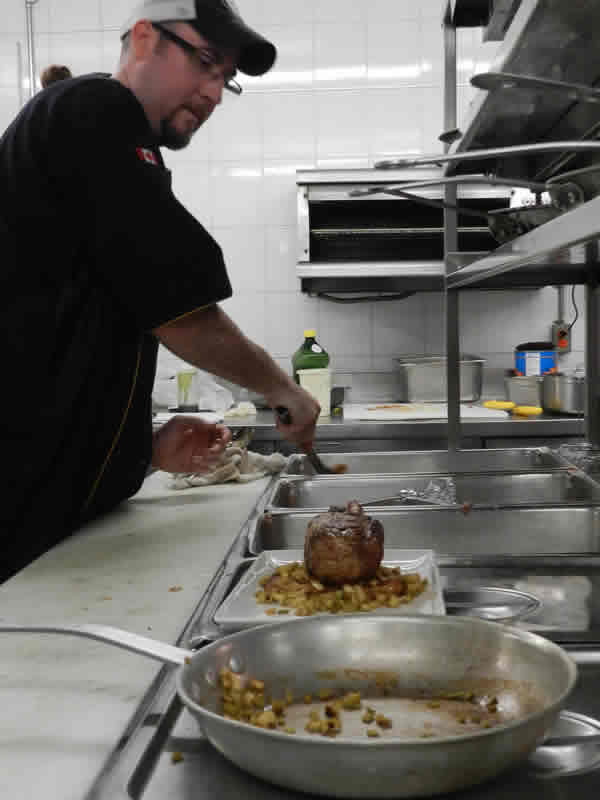 Putting the finishing touches on the Plowman rib-eye inside the kitchen at Prairie 360˚.
