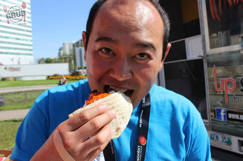 Downtown Winnipeg BIZ's managing director Jason Syvixay chowing down at Food Truck Wars 2014.