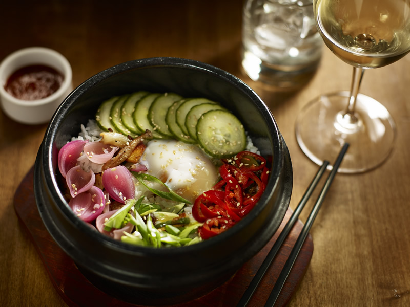Earl's Bibimbap features marinated striploin, crispy jasmine rice, zucchini, oyster mushrooms and carrots, pickled vegetables, sesame chili sauce and a poached egg (Earl's) 