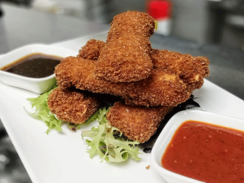Rae's Bistro & Lounge  - 5 home made mozzarella sticks wrapped in fresh sheet pasta and panko crusted, fried until gooey-golden crisp, served with spicy marinara and electric Korean BBQ sauce.